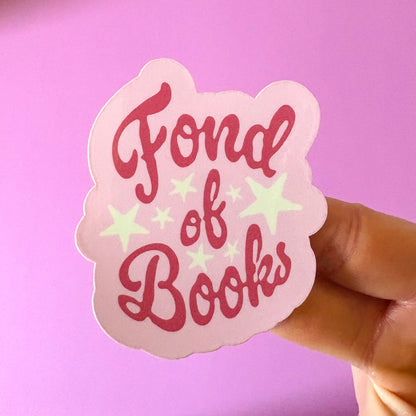 Sticker with 'Fond of Books' text held against a pink background