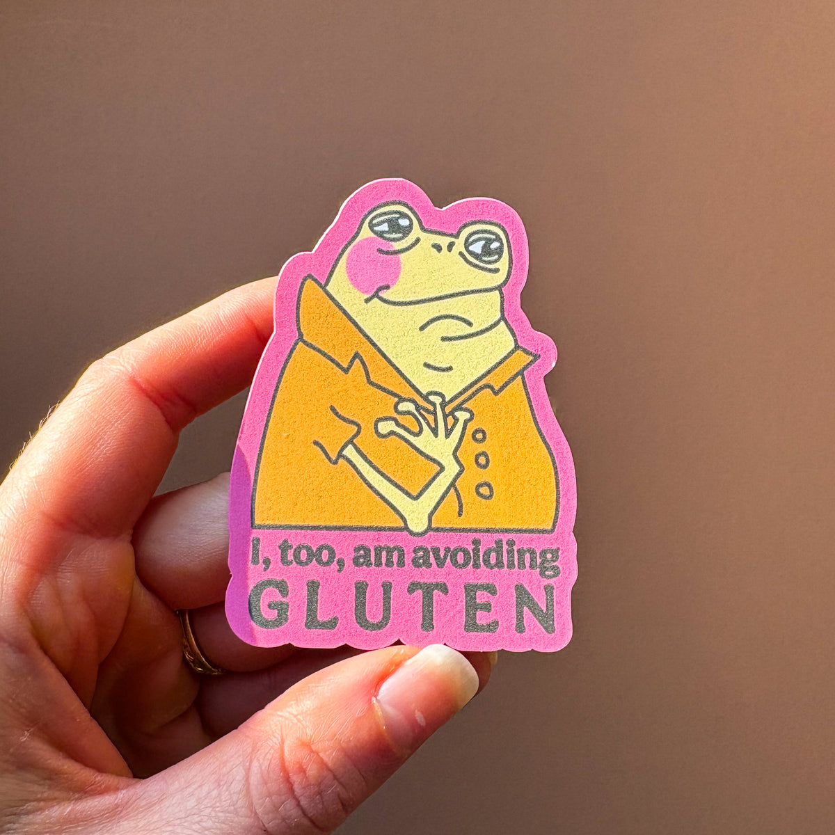 Close-up of the avoiding gluten frog sticker held in a hand