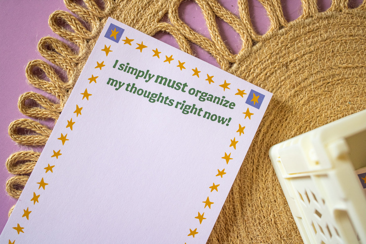 Notepad with text 'I simply must organize my thoughts right now!' on a decorative background