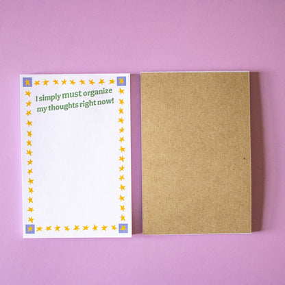 Notebook with a colorful cover and a plain brown cover on a pink background