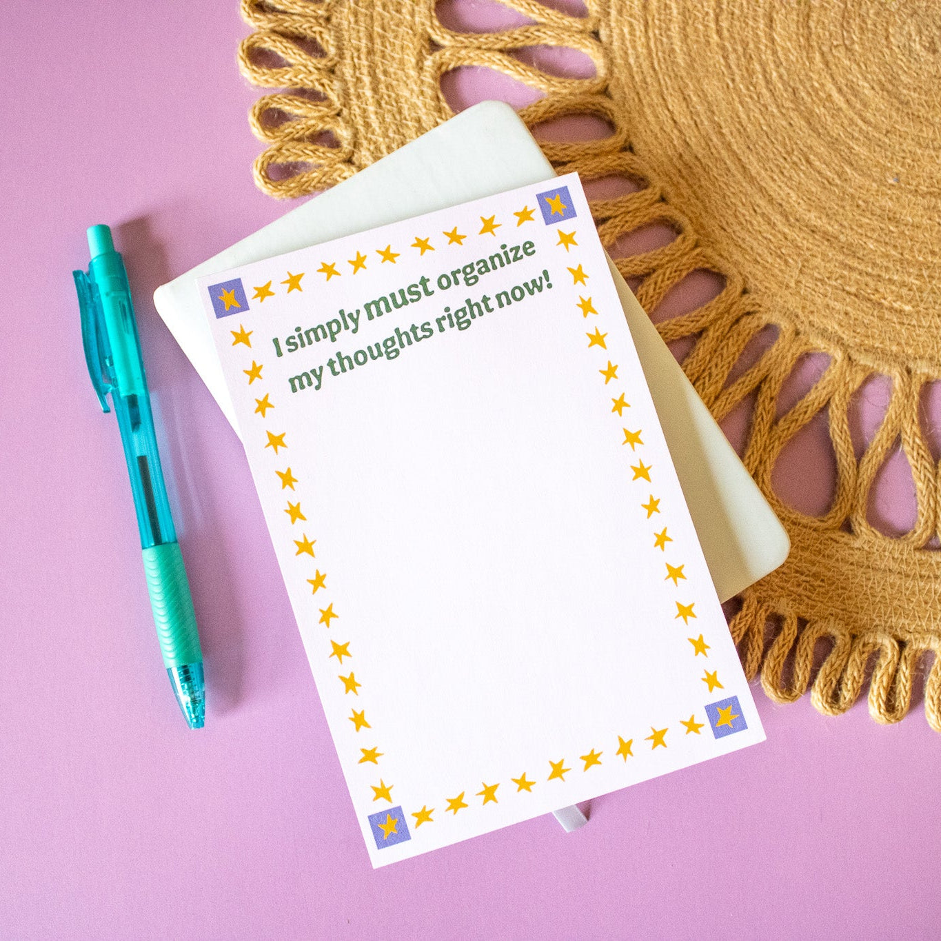 Notepad with a quote on a pink background with a decorative mat