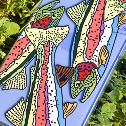 Colorful fish-covered phone case on grass