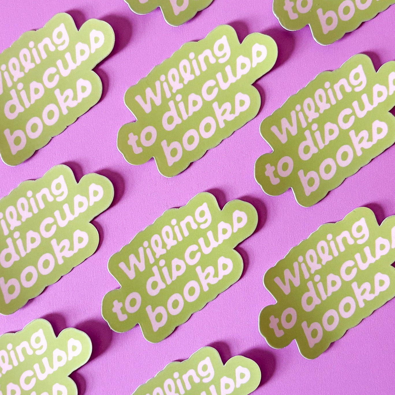 Green stickers with 'Willing to discuss books' text on a pink background